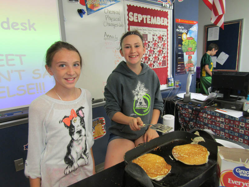 Chloe Nielson and Mariah Wiederholt flip pancakes, September 23, as part of a science lesson on chemical and physical changes. The girls said making pancakes creates a chemical change because the cooking changes the subject.