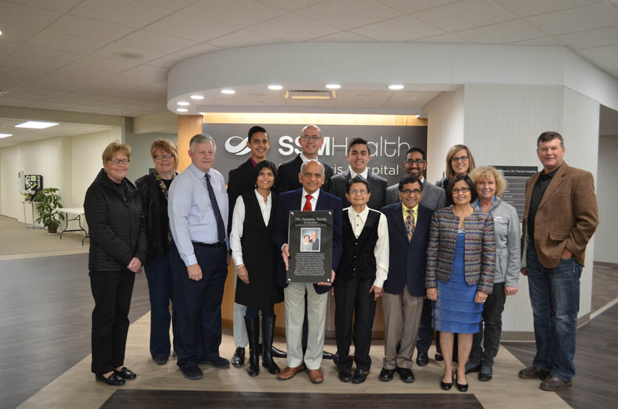 Dr. Kanti and Kokila Havaldar, center with plaque, and their children, grandchildren and St. Francis Hospital Foundation board members and medical group administration celebrate their contributions to the foundation, hospital and community.